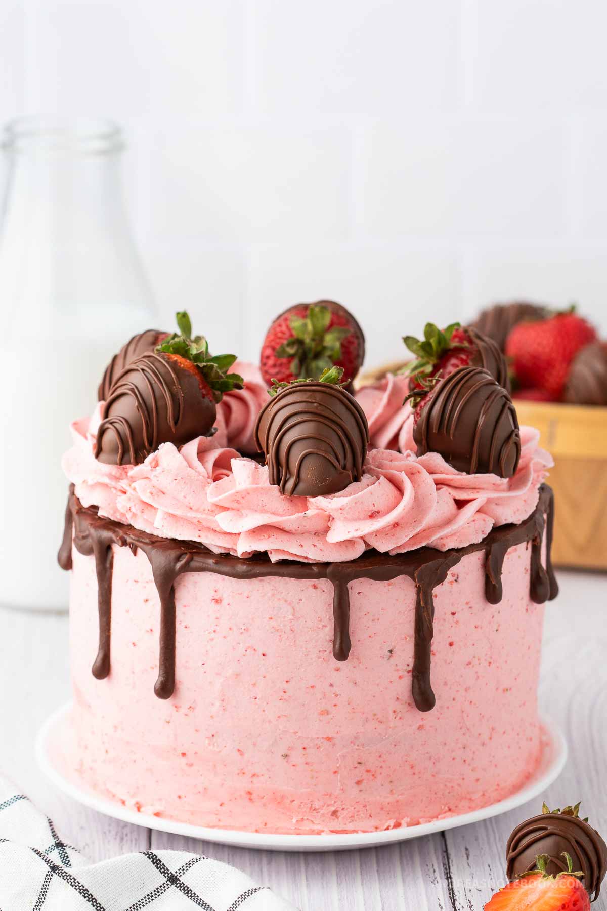 Strawberry chocolate cake with chocolate covered strawberries on top.