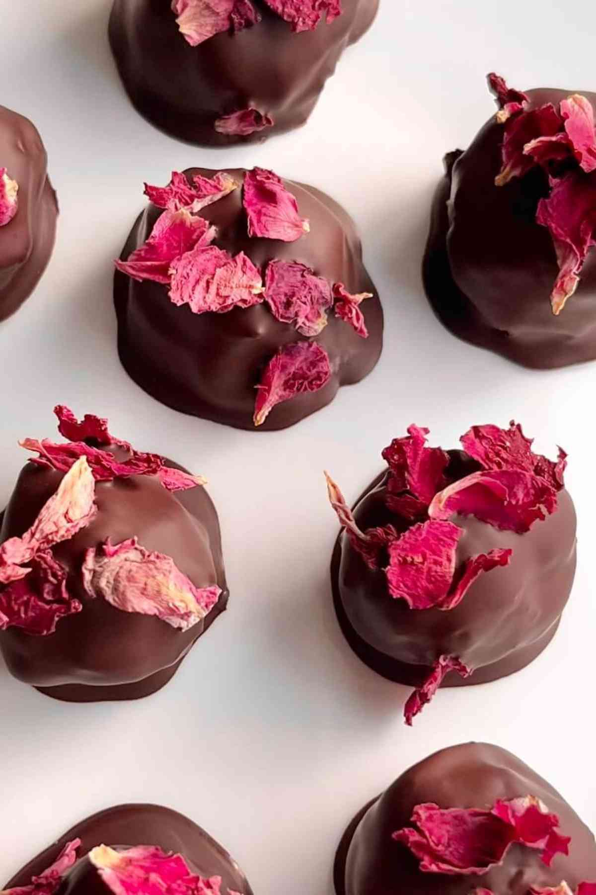 Round chocolate truffles topped with edible rose petals. 