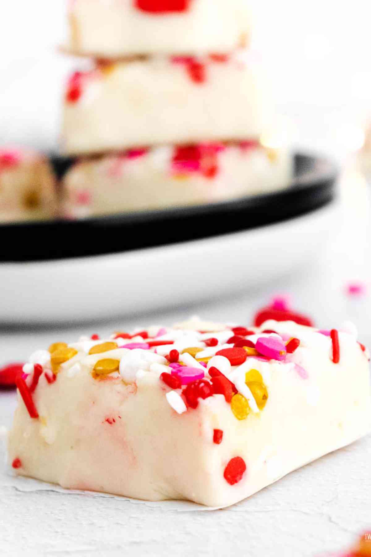Square of white chocolate fudge topped with pink, red and yellow sprinkles.