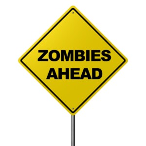 Yellow "zombies ahead" sign on post.
