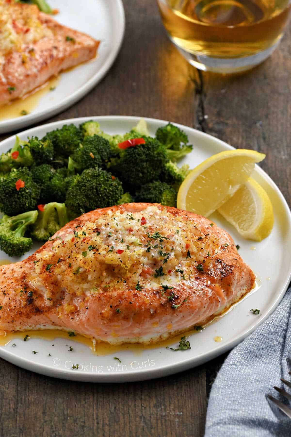 Plate with crab stuffed salmon, broccoli and lemon wedges.