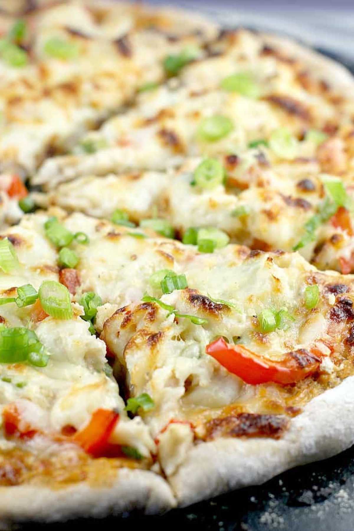 Pizza topped with cheese, red pepper and crab.