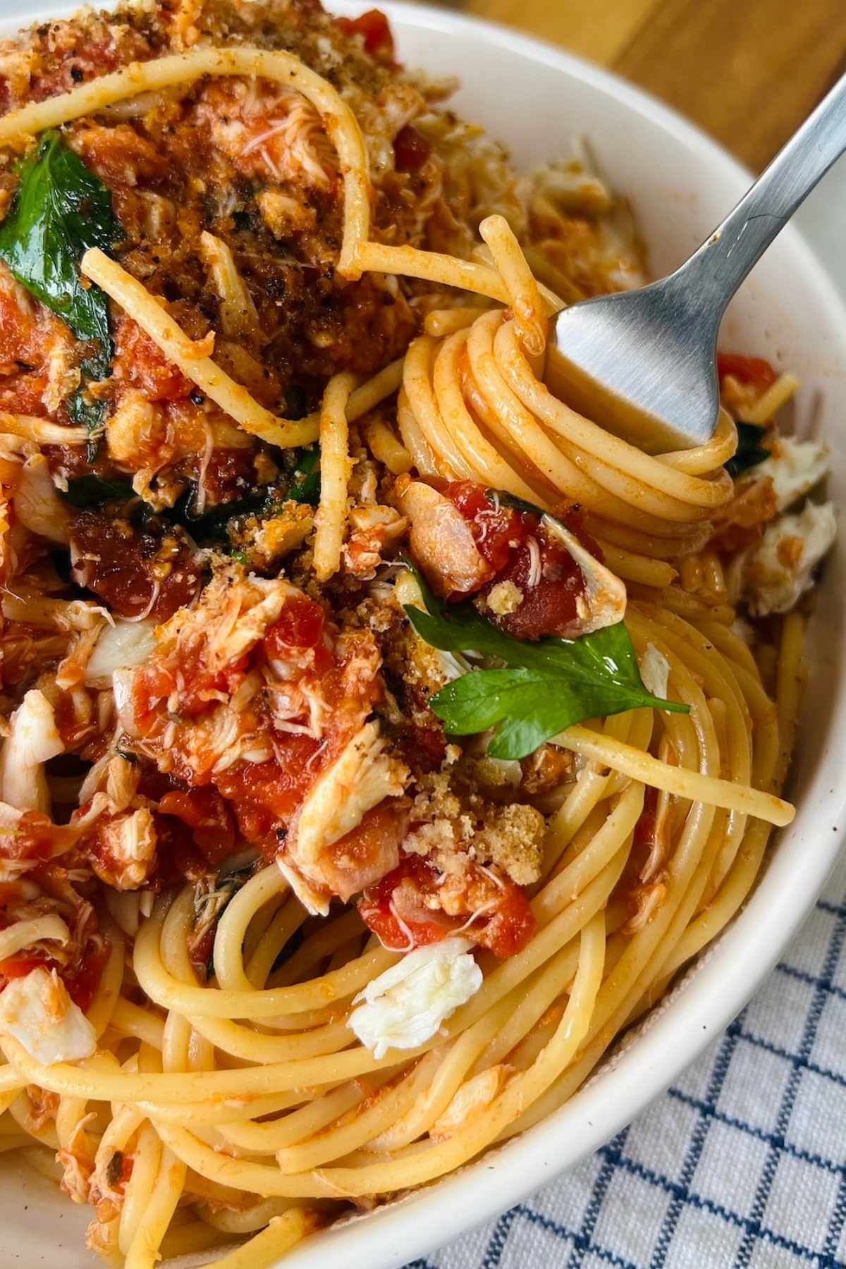 Bowl full of spaghetti with crab on top.
